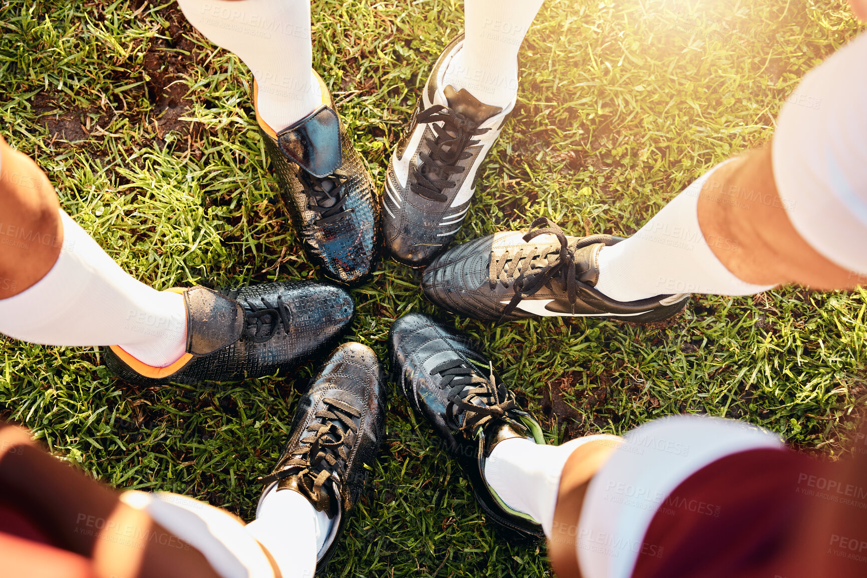 Buy stock photo Shoes, huddle and team on grass field above for sports motivation, coordination or collaboration outdoors. Feet and legs of group in sport circle, fitness training or planning strategy ready for game
