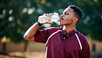 Rugby, sports or black man drinking water in training, exercise or workout match on a field. Fitness, thirsty or tired African athlete drinks liquid in a bottle for energy or hydration in summer