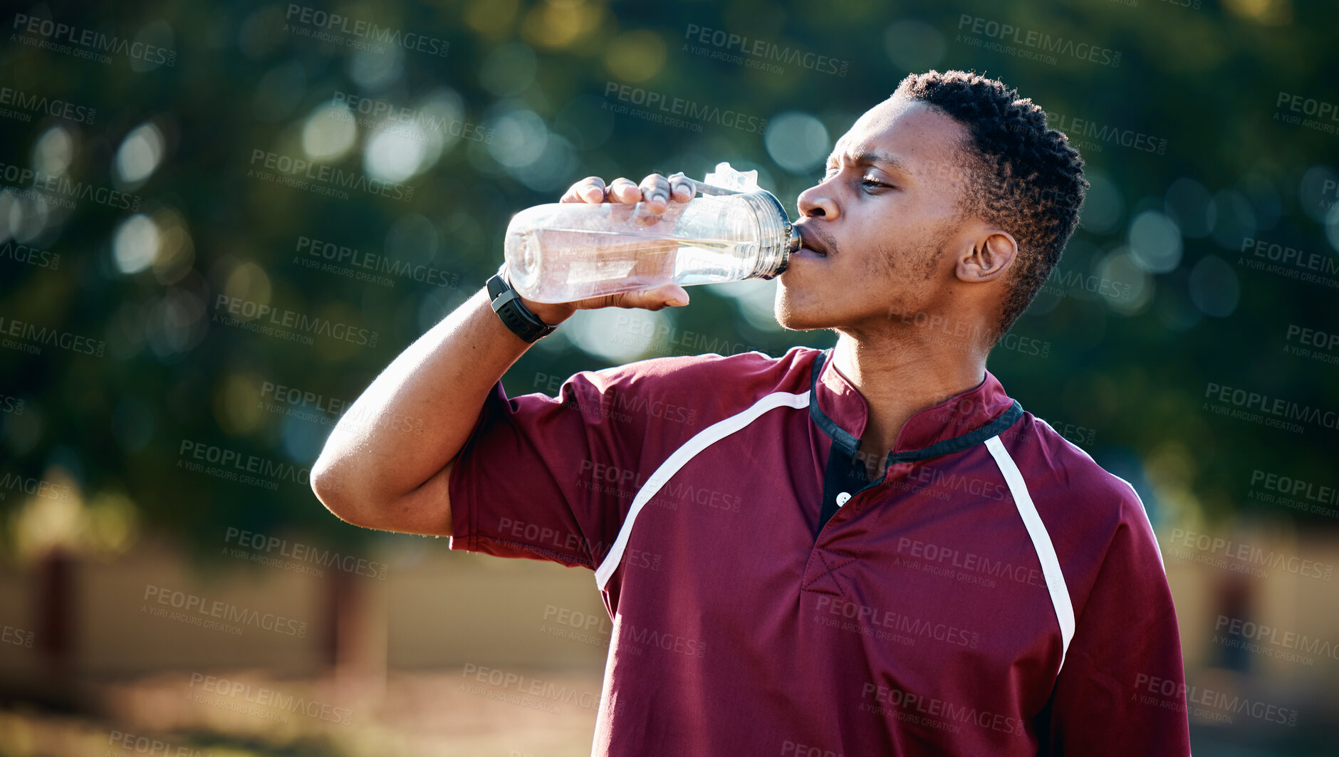Buy stock photo Rugby, sports or black man drinking water in training, exercise or workout match on a field. Fitness, thirsty or tired African athlete drinks liquid in a bottle for energy or hydration in summer