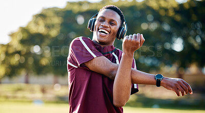Buy stock photo Fitness, headphones and black man stretching for sport and happiness on field, streaming music and exercise. African American male athlete, guy and player stretch arms, workout and training outside