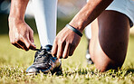 Man, hands and shoe tying laces getting ready for sports training, exercise or match and game on grass field. Hand of male in preparation, tie shoes and sport for fitness, start or soccer practice