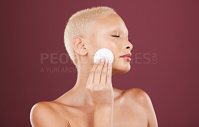 Buy stock photo Face, skincare and woman with cotton pad in studio isolated on a red background. Beauty dermatology, eyes closed and female model with facial product for cleaning makeup, cosmetics and healthy skin.
