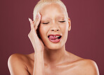 Eyes closed, tongue out and face skincare of woman in studio isolated on a red background. Dermatology, makeup cosmetics and beauty of female model satisfied after facial treatment for healthy skin.