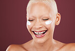 Face cream, smile and beauty skincare of woman in studio isolated on a red background. Dermatology aesthetic, cosmetics and happy female model laughing with facial lotion, creme and moisturizer.