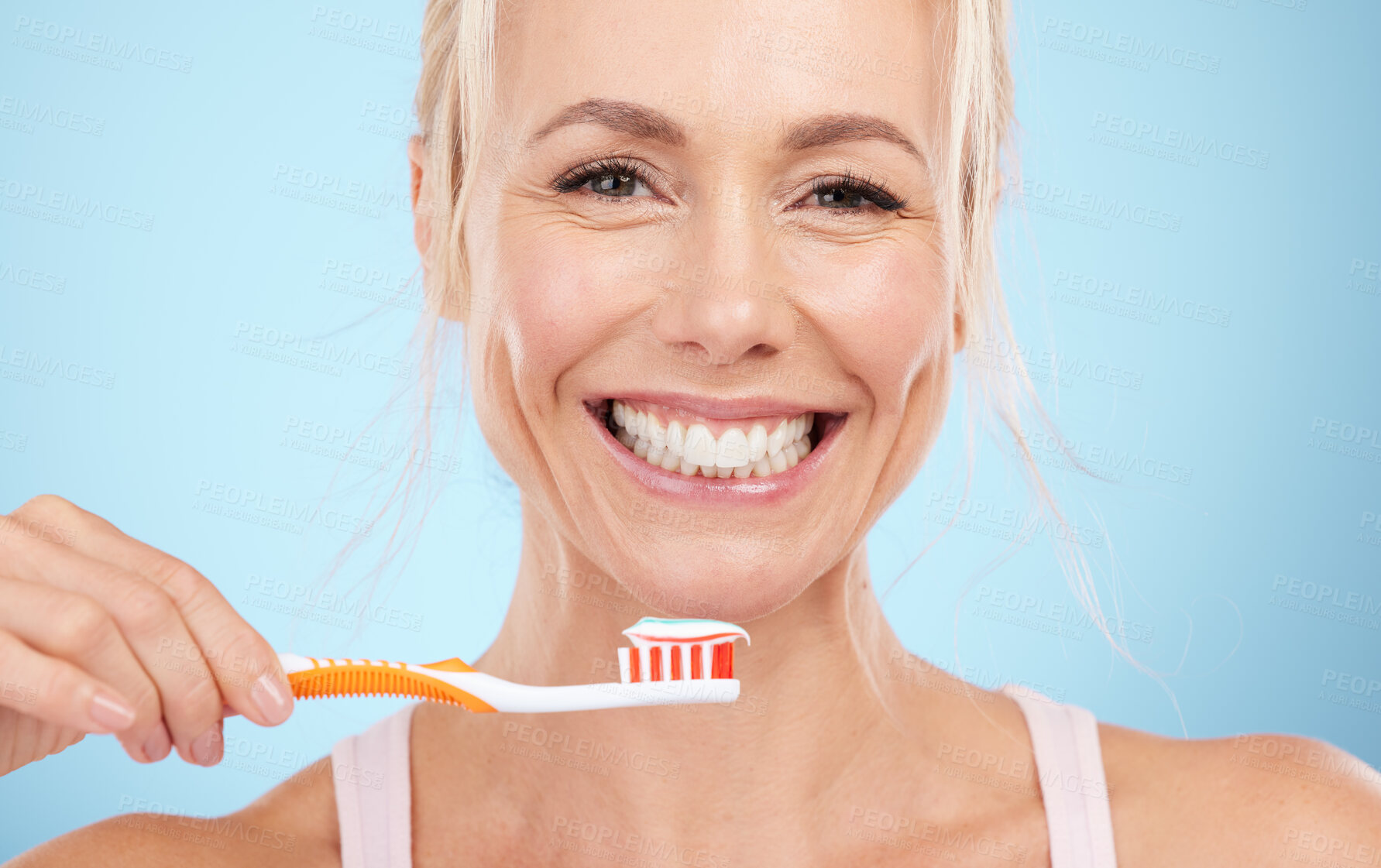 Buy stock photo Portrait, mature woman and brushing teeth isolated on blue background in dental, mouth or orthodontics healthcare. Beauty model or happy person face for toothbrush product and toothpaste in studio