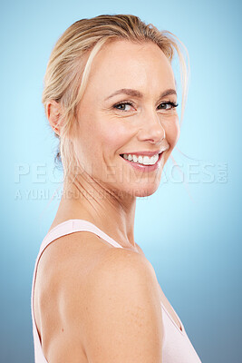 Skincare, woman and portrait in studio for beauty, dermatology and wellness cosmetics on blue background. Happy mature female model, facial and smile for aesthetic glow, botox transformation and face