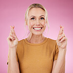 Woman, fingers crossed and smile in studio, pink background and good luck face. Excited female model hope for bonus, promotion and winning giveaway with hand emoji sign, competition prize and lottery