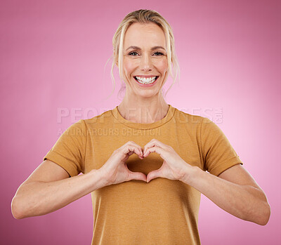Buy stock photo Heart, hands and portrait of woman on pink background, studio and color backdrop with emoji, care and kindness. Happy female model with finger shape for love, thank you and smile in support of peace