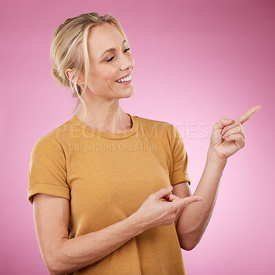 Buy stock photo Happy, pointing and female model in studio to mockup for advertisement or product placement. Happiness, excited and woman from Canada showing with her finger mock up for marketing by pink background.