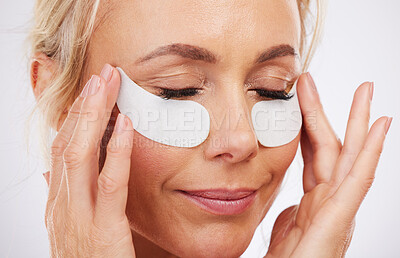 Buy stock photo Skincare, eye mask and collagen, mature woman, anti ageing wrinkle treatment and isolated on grey background in studio. Health, skin and beauty model face with patches on eyes for luxury spa facial.
