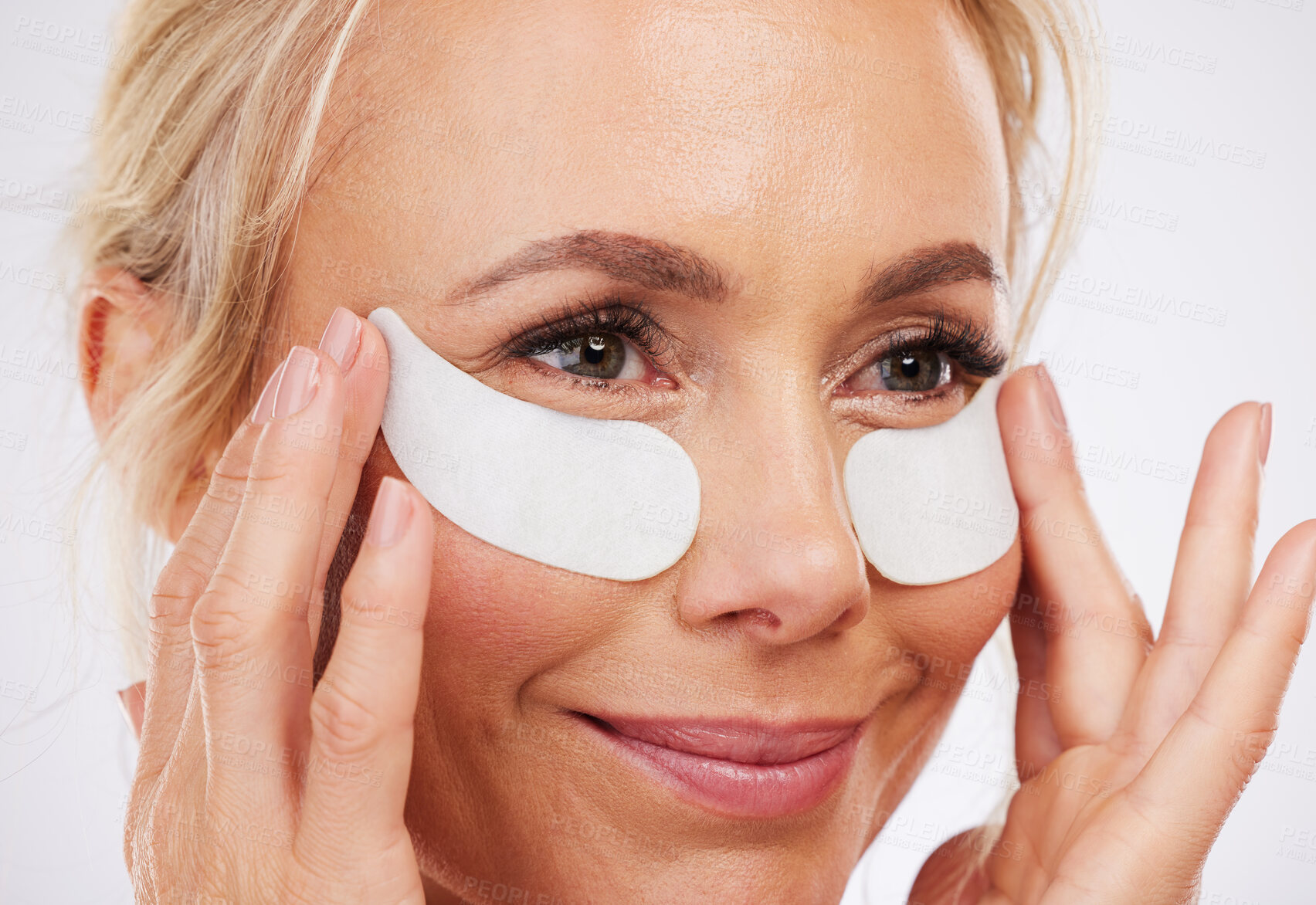 Buy stock photo Skincare, eye mask and mature woman with smile, anti ageing wrinkle treatment and isolated on grey background in studio. Health, skin and model face with collagen patch on eyes in luxury spa facial.
