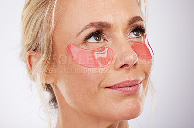 Buy stock photo Skincare, collagen eye mask and mature woman with anti ageing treatment isolated on grey background in studio. Health, skin and beauty, model face with smile and patch on eyes for luxury spa facial.