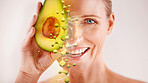 Face, skincare and senior woman with avocado in studio isolated on a gray background. Portrait, cosmetics overlay and happy female model with fruit for nutrition, vitamin c or healthy diet for beauty