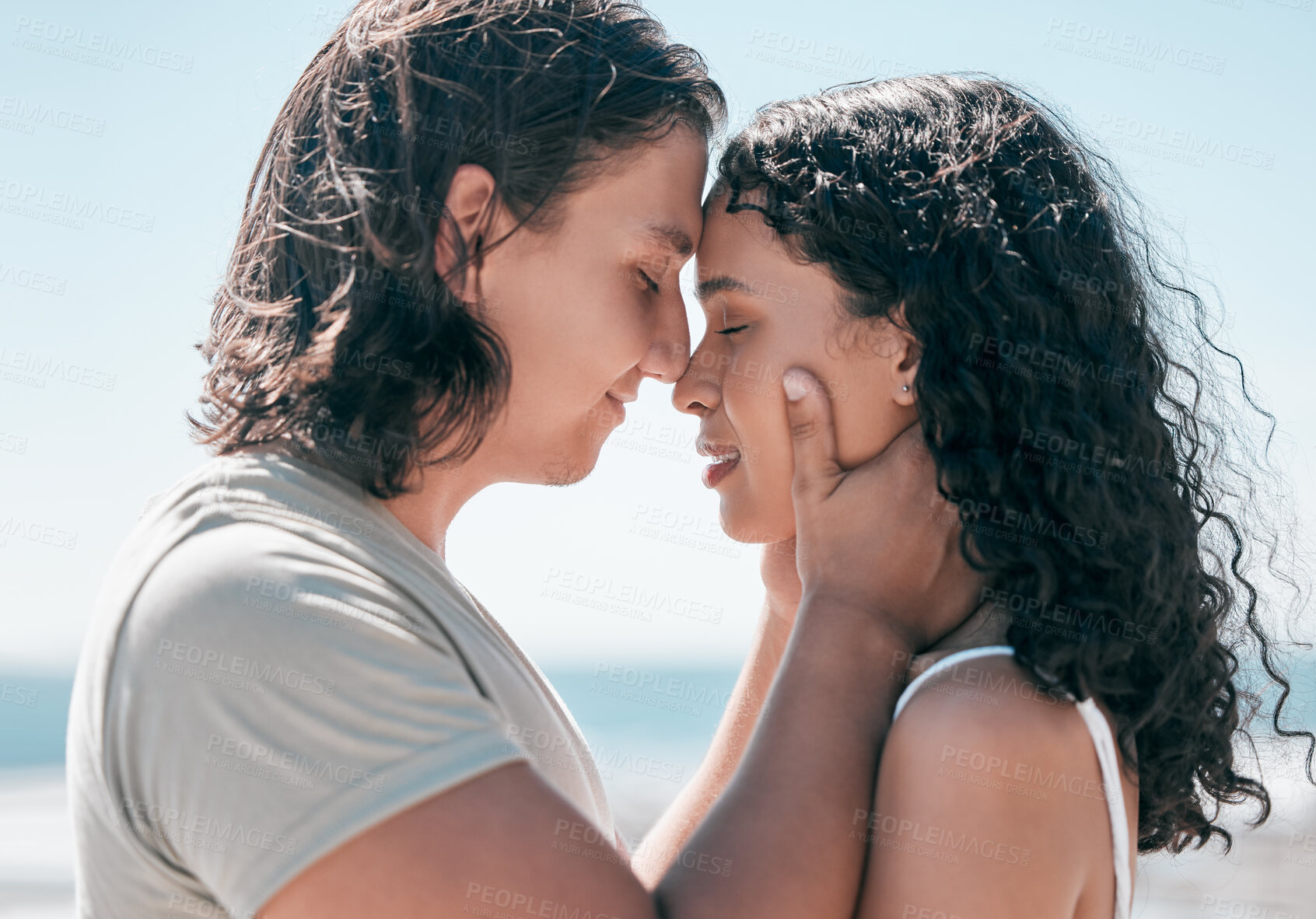 Buy stock photo Love, hands on face and couple relax at a beach, in love and romantic on blue sky background. Intimate, moment and romance by man with woman on ocean trip, sweet and calm relationship moment in Bali