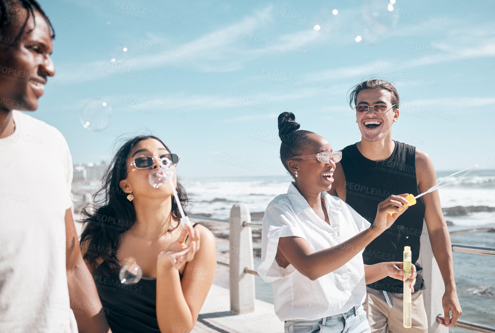 Buy stock photo Bubble, beach and summer with friends walking outdoor together on the promenade during vacation. Nature, diversity and freedom with a group of people bonding outside by the ocean or sea on holiday