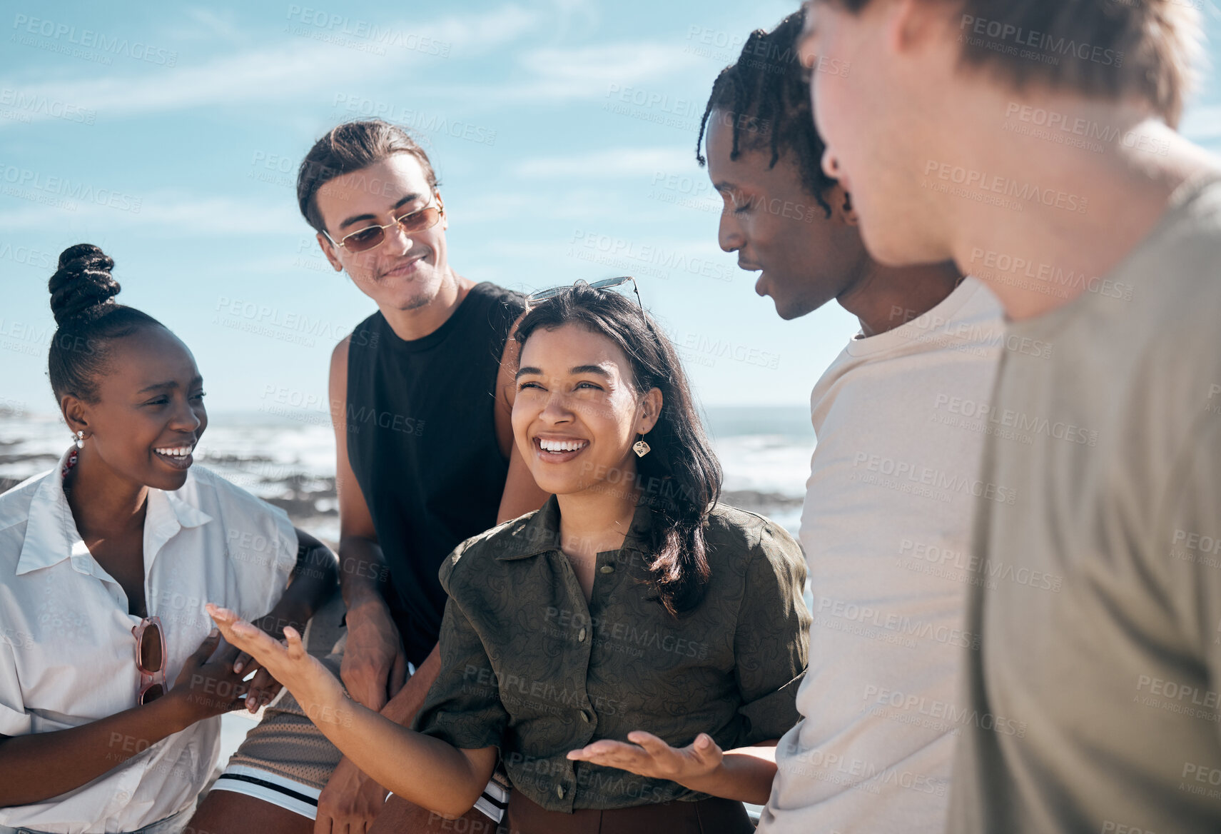 Buy stock photo Woman, talking and bonding people by beach, ocean or sea in group social gathering, holiday community or summer storytelling. Smile, happy and diversity friends in travel location, relax or freedom