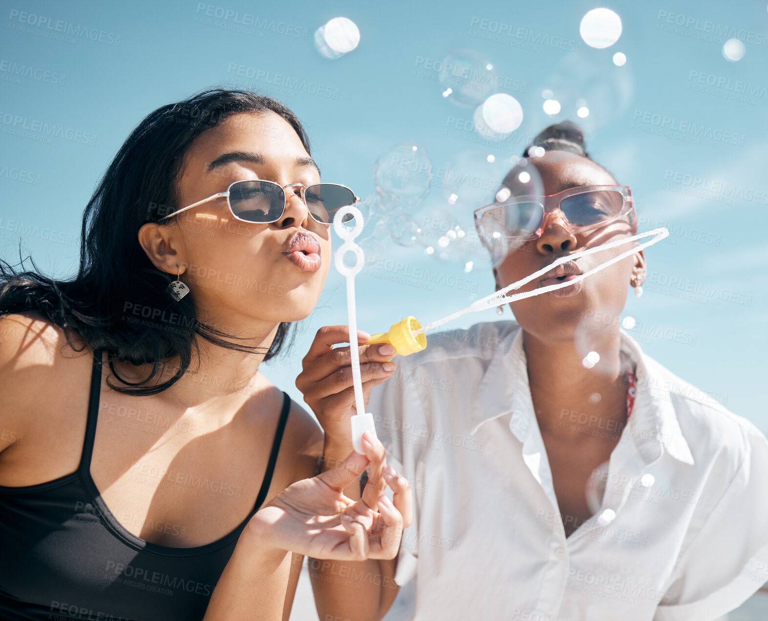 Buy stock photo Woman, friends, and blowing bubbles by beach, ocean or sea on summer vacation, holiday travel or bonding activity. Women playing with soap or bubble wand or toy in fun game, freedom or social break