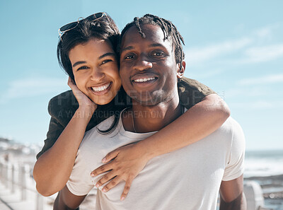 Buy stock photo Happy couple, portrait and piggyback by beach in relax romance holiday, love vacation date or summer travel location. Smile, bonding and man carrying black woman in fun game, freedom trust or support