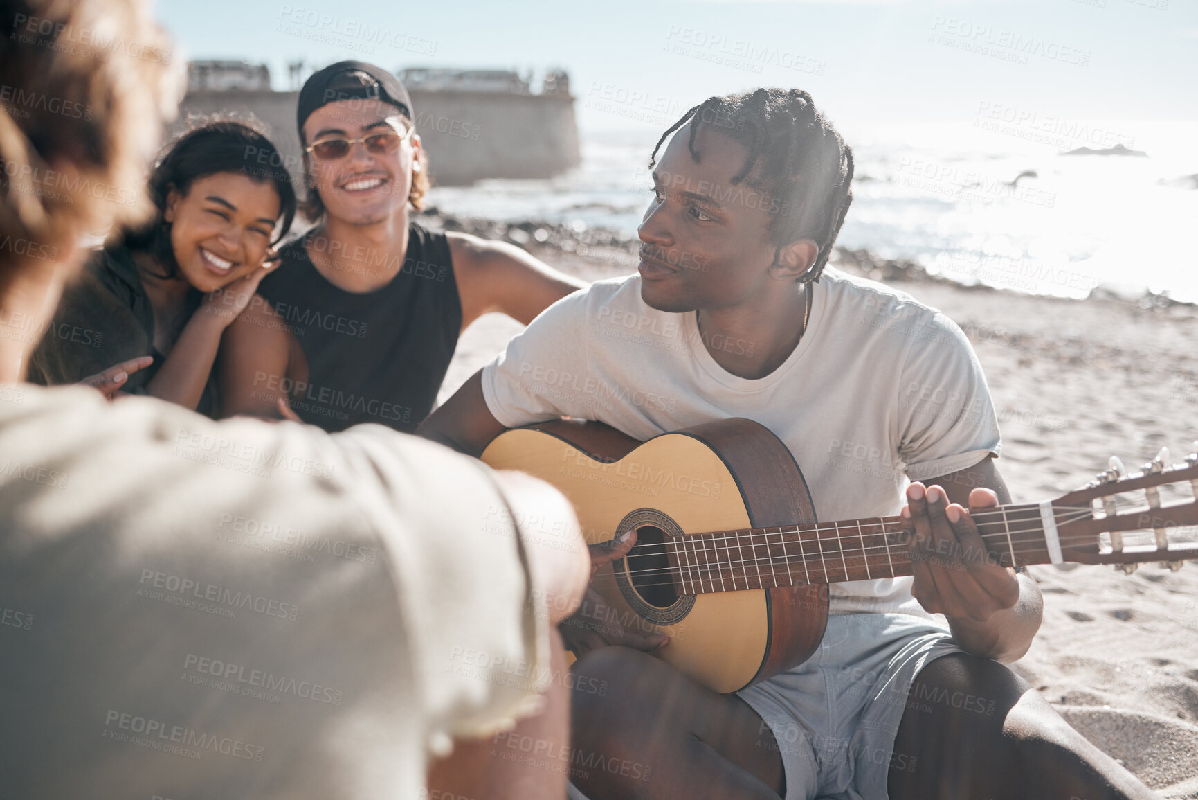 Buy stock photo Black man, friends or playing guitar by beach, ocean or sea in holiday vacation, summer travel or social gathering. Smile, happy or couple of friends with musical instrument in relax diversity picnic