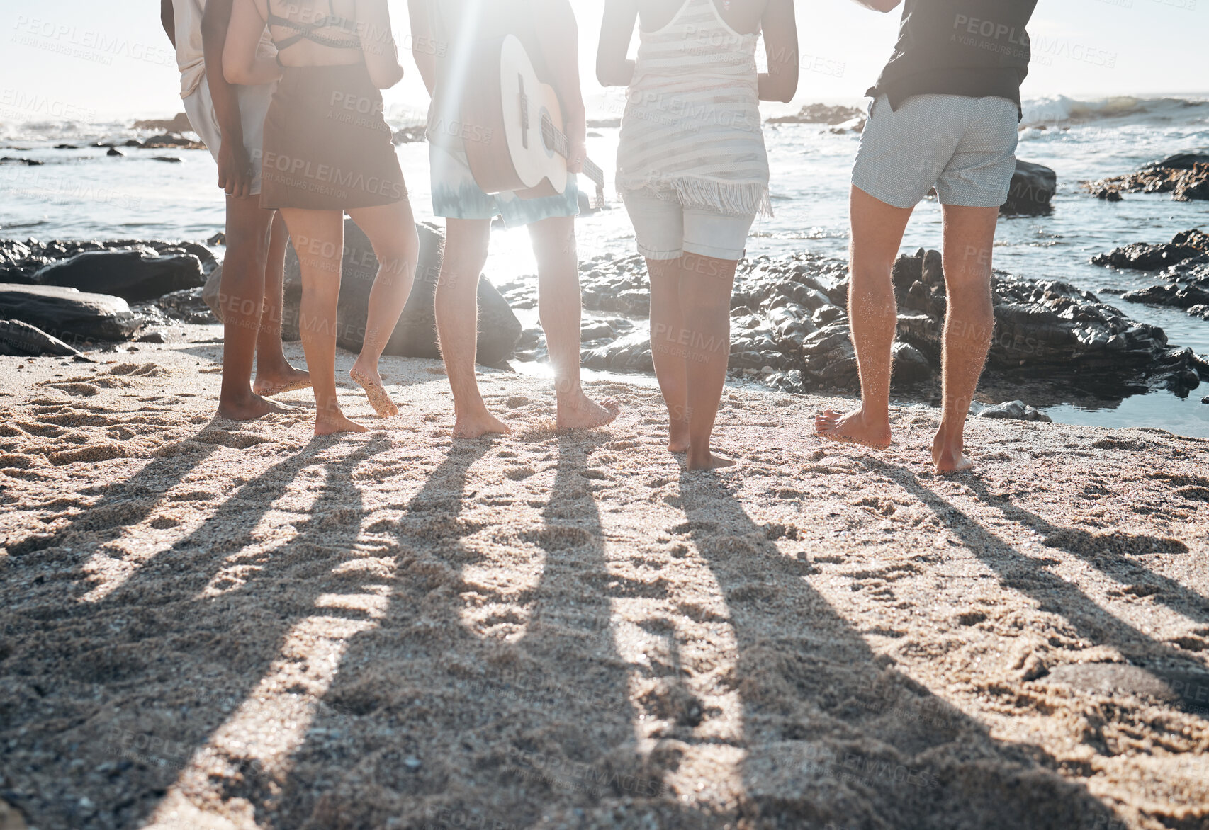 Buy stock photo Friends, back or standing legs on beach, sand or ocean sea in social gathering, group vacation or summer holiday with guitar. Men, women or diversity people with musical instrument in travel bonding