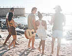 Friends group, beach and diversity with guitar, bonding, and love with black man, women and musician. Young student vacation, ocean chat and outdoor adventure for music together in summer sunshine