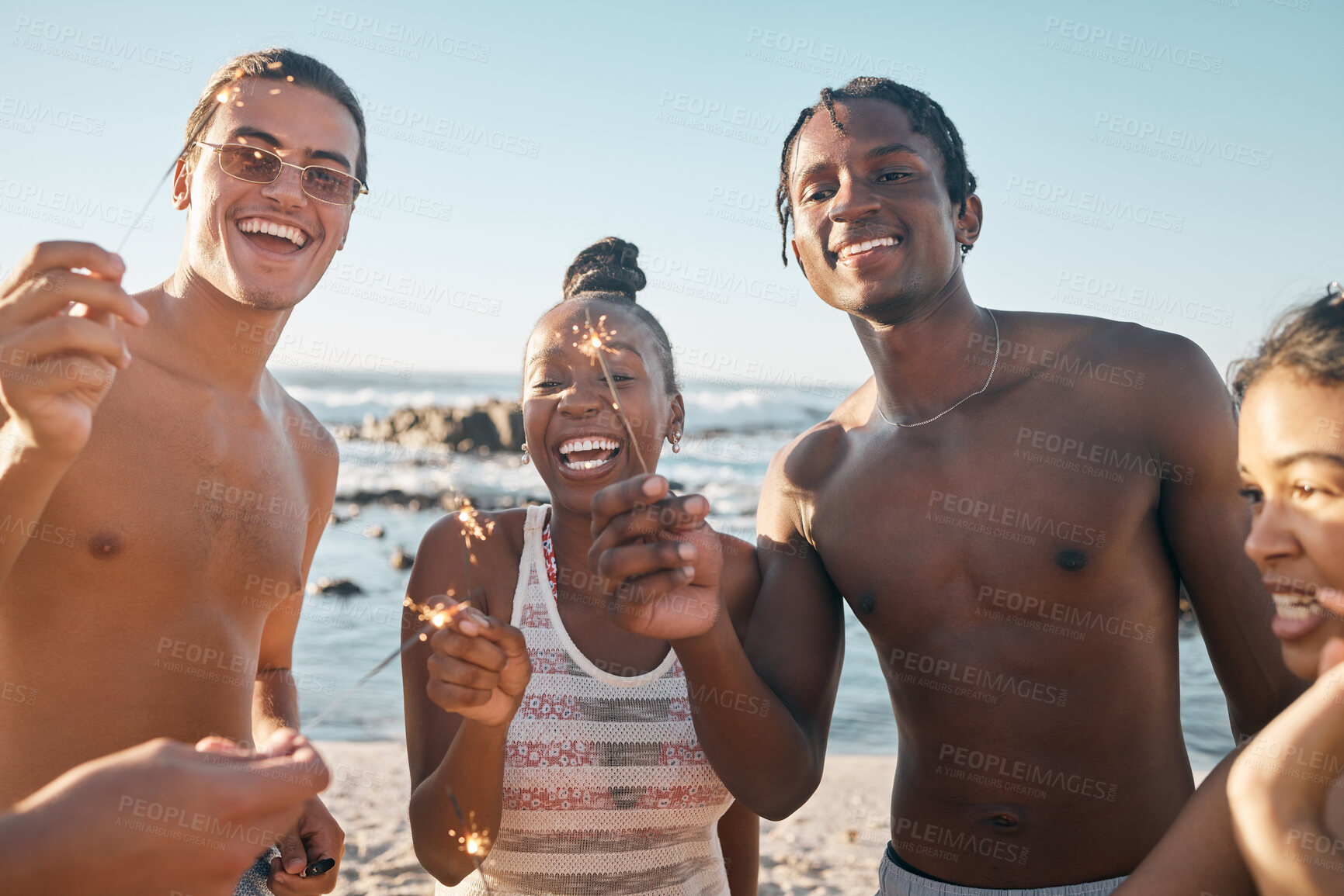 Buy stock photo Friends, bonding or sparkler in beach celebration, party event or birthday social gathering. Fireworks, sparkle or fun stick for smile, happy men or diversity women in new years day or holiday travel