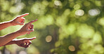 Hands, finger and pointing sign on nature mockup for product placement, advertising or marketing. Hand of group showing fingers in point for location, direction or sightseeing outdoors on bokeh