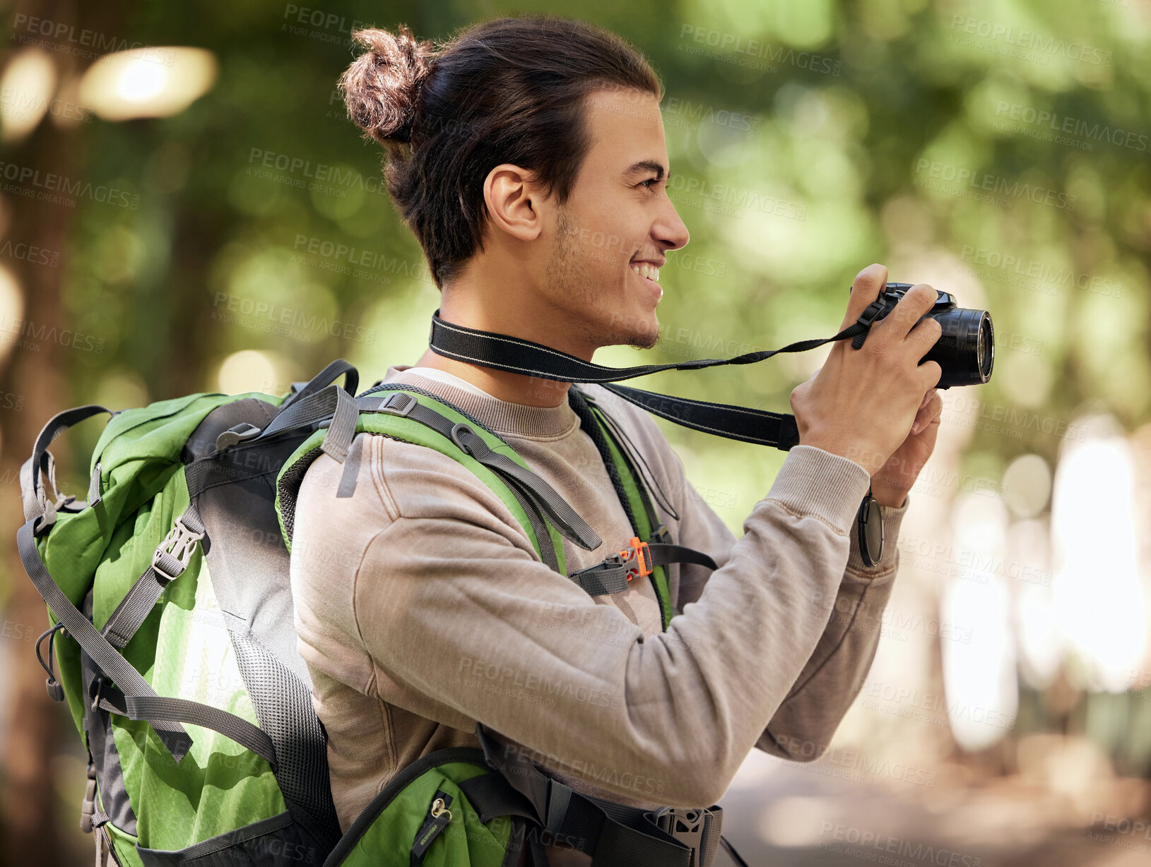 Buy stock photo Photography man, camera and outdoor park with smile, focus or adventure with creative vision. Young nature journalist, expert photographer and bird watching with tech, hiking or backpack for research