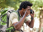 Fitness, black man and hiking with camera, forest and tourism in nature, capture moment and wilderness. African American male, hiker and tourist taking pictures, exercise and walking in mountains