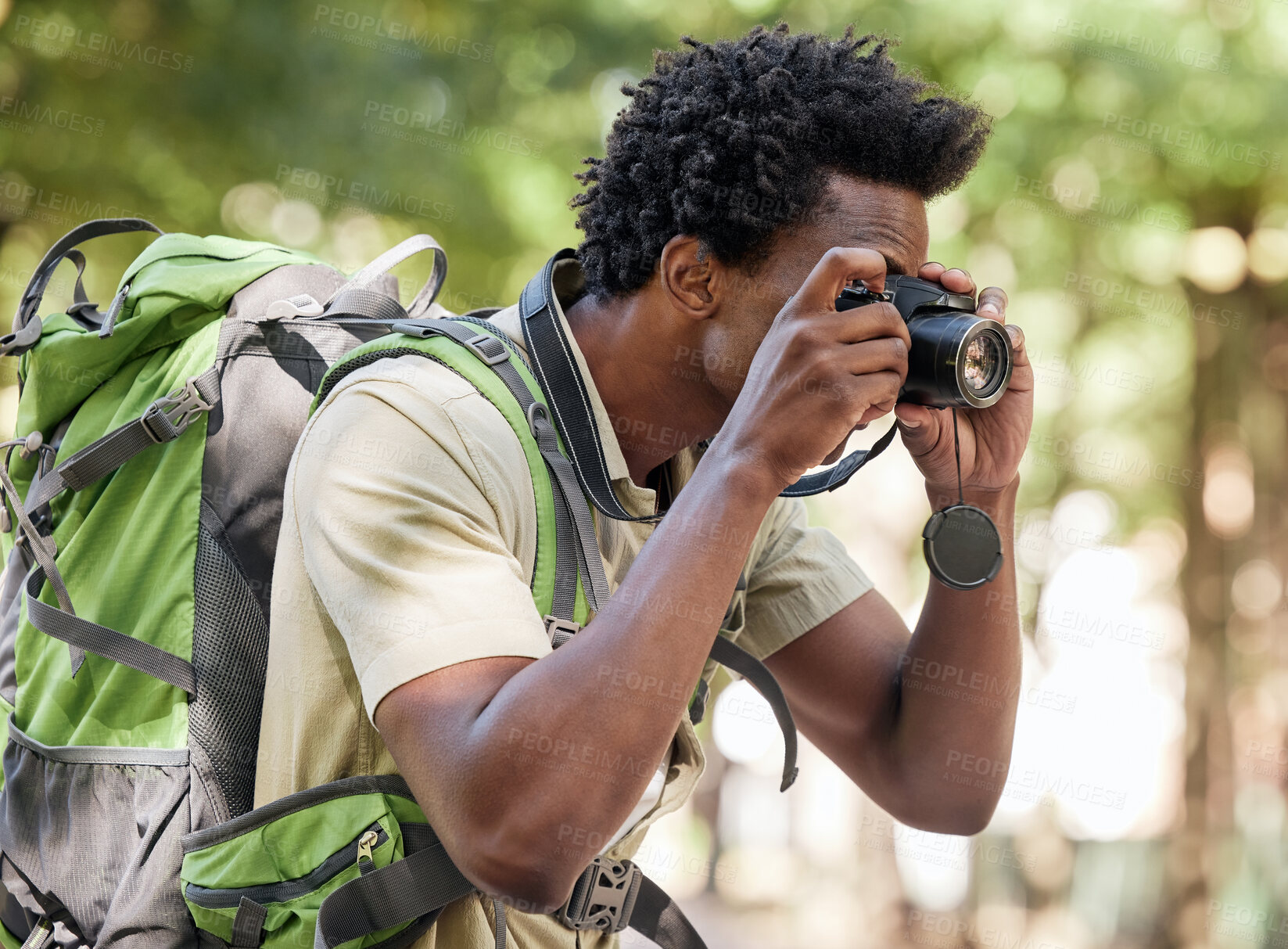 Buy stock photo Fitness, black man and hiking with camera, forest and tourism in nature, capture moment and wilderness. African American male, hiker and tourist taking pictures, exercise and walking in mountains