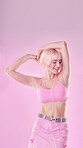Fashion, dance and woman isolated on pink background listening to music with cosmetics and pastel aesthetic. Happy, gen z model or person dancing with audio for fun, freedom and self love in studio