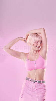 Buy stock photo Fashion, dance and woman isolated on pink background listening to music with cosmetics and pastel aesthetic. Happy, gen z model or person dancing with audio for fun, freedom and self love in studio