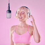 Headphones, microphone and woman singer in a studio recording a song, album or music. Happy, passion and young female artist or musician singing with equipment while isolated by a pink background.