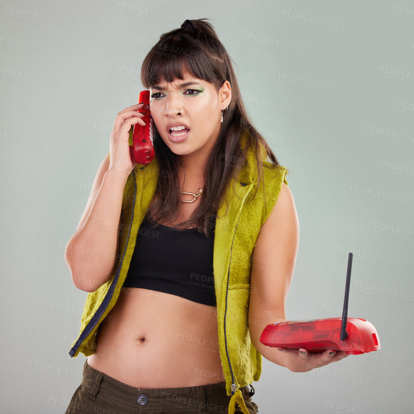 Buy stock photo Angry, problem and woman with a telephone for a conversation isolated on a grey studio background. Stress, frustrated and mad girl speaking on a vintage landline phone for communication and conflict