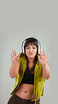 Music, dance and portrait of woman with headphones in studio, happy and excited isolated on grey background. Streaming service, song and gen z fashion, girl dancing with hands up to online radio dj.