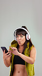 Punk, smartphone or woman with headphones, excited or dancing on grey studio background. Hipster, happy female or lady with cellphone, headset or streaming for music, audio or celebration on backdrop