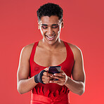 Fashion, phone and gay man on social media in studio on a red background for communication. Mobile, transgender and a happy lgbt person looking at an internet meme while fashionable on a backdrop