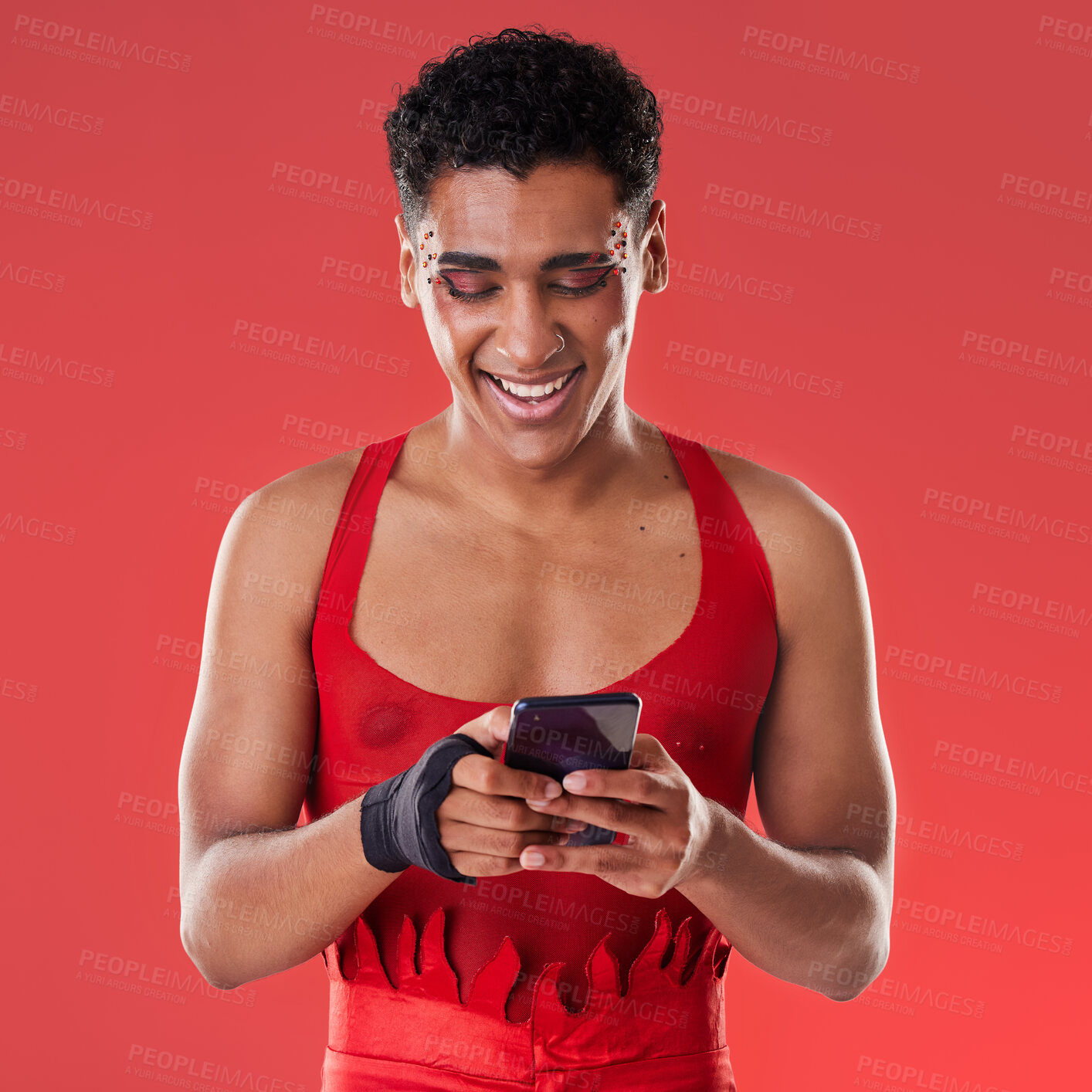Buy stock photo Fashion, phone and gay man on social media in studio on a red background for communication. Mobile, transgender and a happy lgbt person looking at an internet meme while fashionable on a backdrop