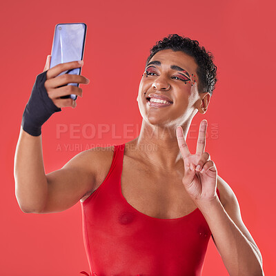 Buy stock photo Selfie, queer and gay man peace sign gesture for social media update isolated against a studio red background. LGBTQ, non binary and gen z fashion model with online photo for the internet