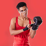 Gay man, studio and boxing glove on hand with punk costume, makeup and lgbt aesthetic by red background. Young bodybuilder, gen z fighter and fitness with strong body, self care and pride for boxer