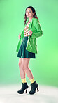 Fashion, beauty and portrait of a woman in a studio with a trendy, stylish and edgy outfit. Happy, smile and young female model with style and cool clothes posing while isolated by a green background