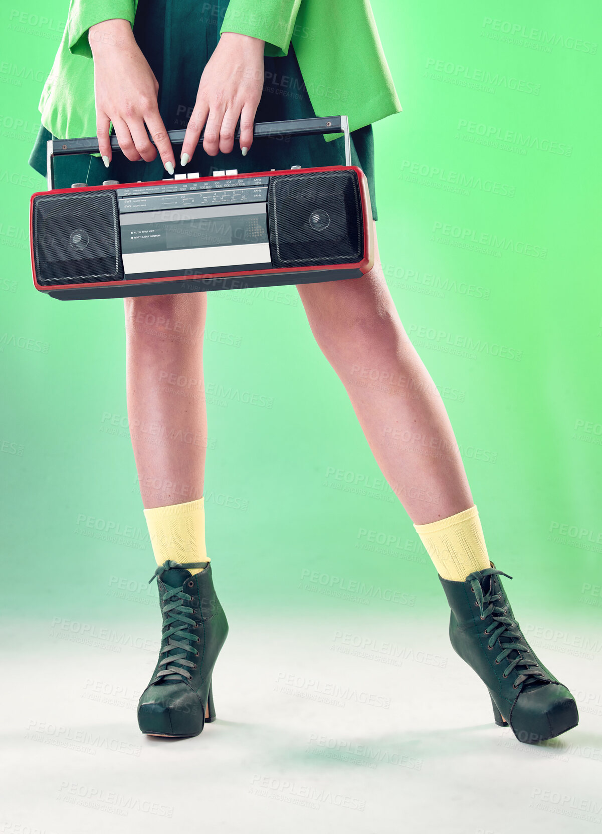 Buy stock photo Radio, woman and music with retro technology and fashion, entertainment with station, funk and legs on green background. Style, vintage sound and audio equipment, female boots with broadcast device