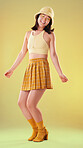 Dancing, Asian woman and retro fashion isolated on a yellow background in a studio. Happy and stylish girl model with dance for freedom, motivation and carefree mindset with cosmetics and energy