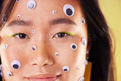 Buy stock photo Gen z, eyes sticker art and portrait of an Asian woman with makeup and colorful cosmetics. Creative googly eye application, style influencer and cosmetic creativity of a model with studio background