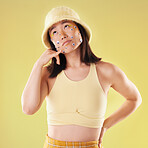 Eyes, thinking and woman with a hand call isolated on a yellow background in a studio. Idea, fashion and Asian girl with fingers in a telephone gesture for communication, conversation and talking