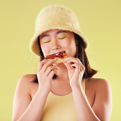 Buy stock photo Asian girl, eating pizza and studio with fashion, happiness and retro 90s aesthetic by yellow background. Young gen z model, junk food and happy with meal, cheat snack and beauty with facial makeup