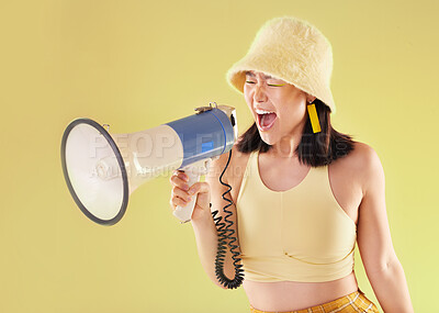 Buy stock photo Asian, girl and studio with megaphone for protest, shout and speech for human rights by background. Young gen z model, loudspeaker voice and yellow 90s aesthetic for change, justice or opinion
