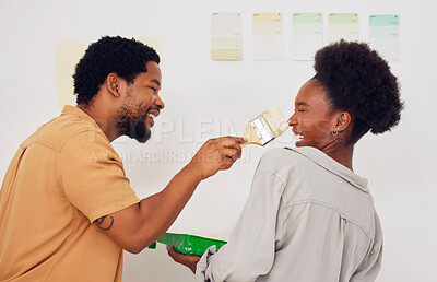 Buy stock photo Painting, funny or happy black couple in DIY, home renovation or house remodel together with a paintbrush. Playing, smile or crazy African man laughing with woman working or decorating with team work