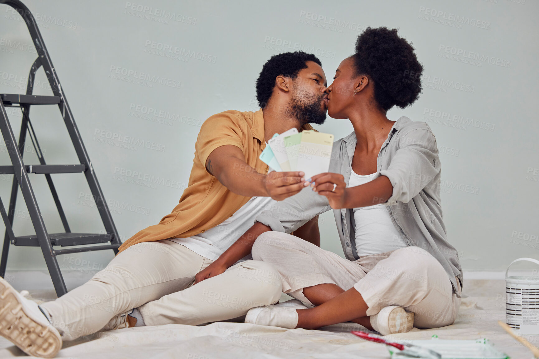 Buy stock photo Painting color, love or black couple kiss in home renovation, diy or house remodel together by apartment ladder. Design, choices or African man kissing pregnant woman excited about baby or new family