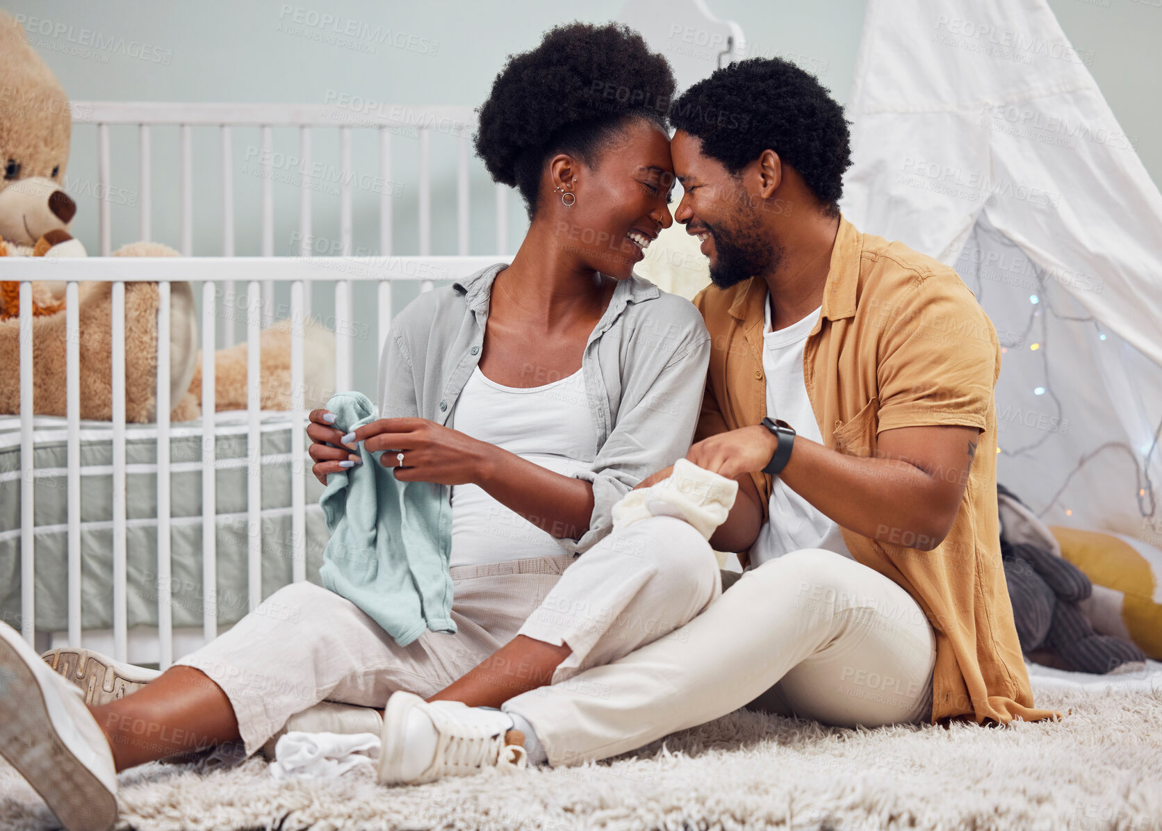 Buy stock photo Love, laundry and black couple getting ready for a baby, folding clothes and preparation in pregnancy. Happy, parents and pregnant woman and man sitting with clothing for child, affection and relax